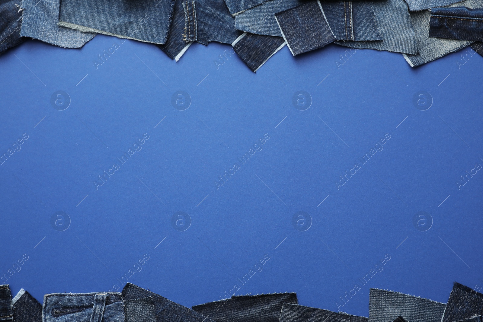 Photo of Frame made of cut jeans on blue background, top view. Space for text