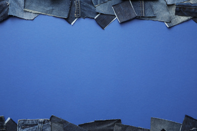 Frame made of cut jeans on blue background, top view. Space for text