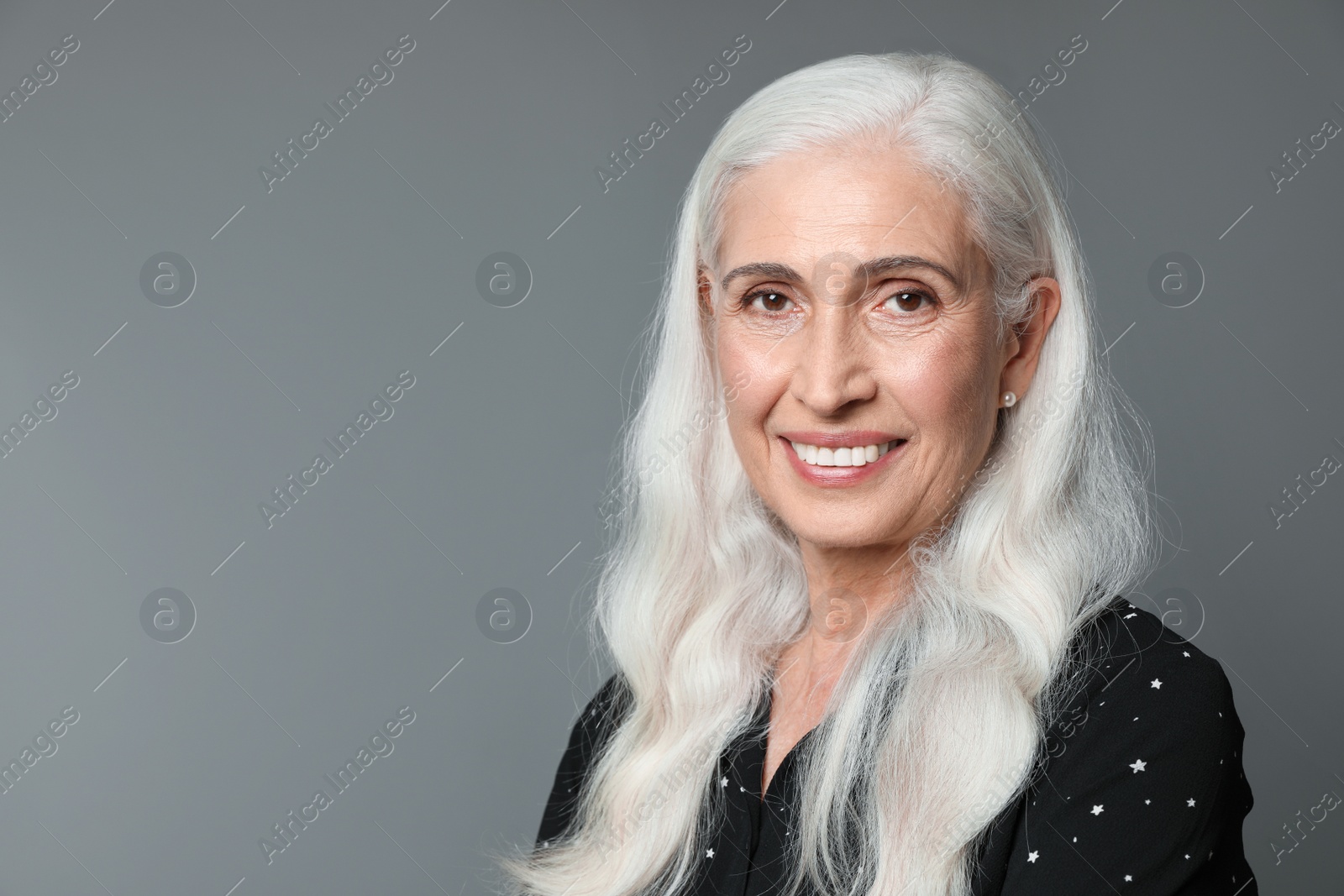 Photo of Portrait of beautiful mature woman on grey background, space for text