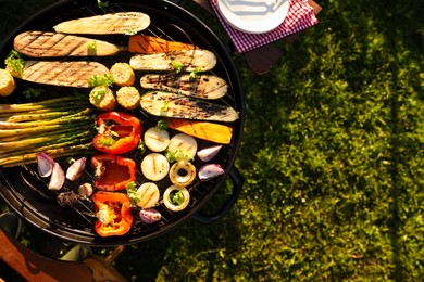 Photo of Delicious grilled vegetables on barbecue grill outdoors, top view. Space for text