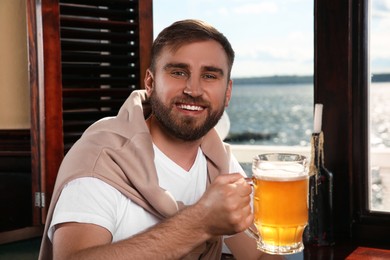 Man with glass of tasty beer in pub