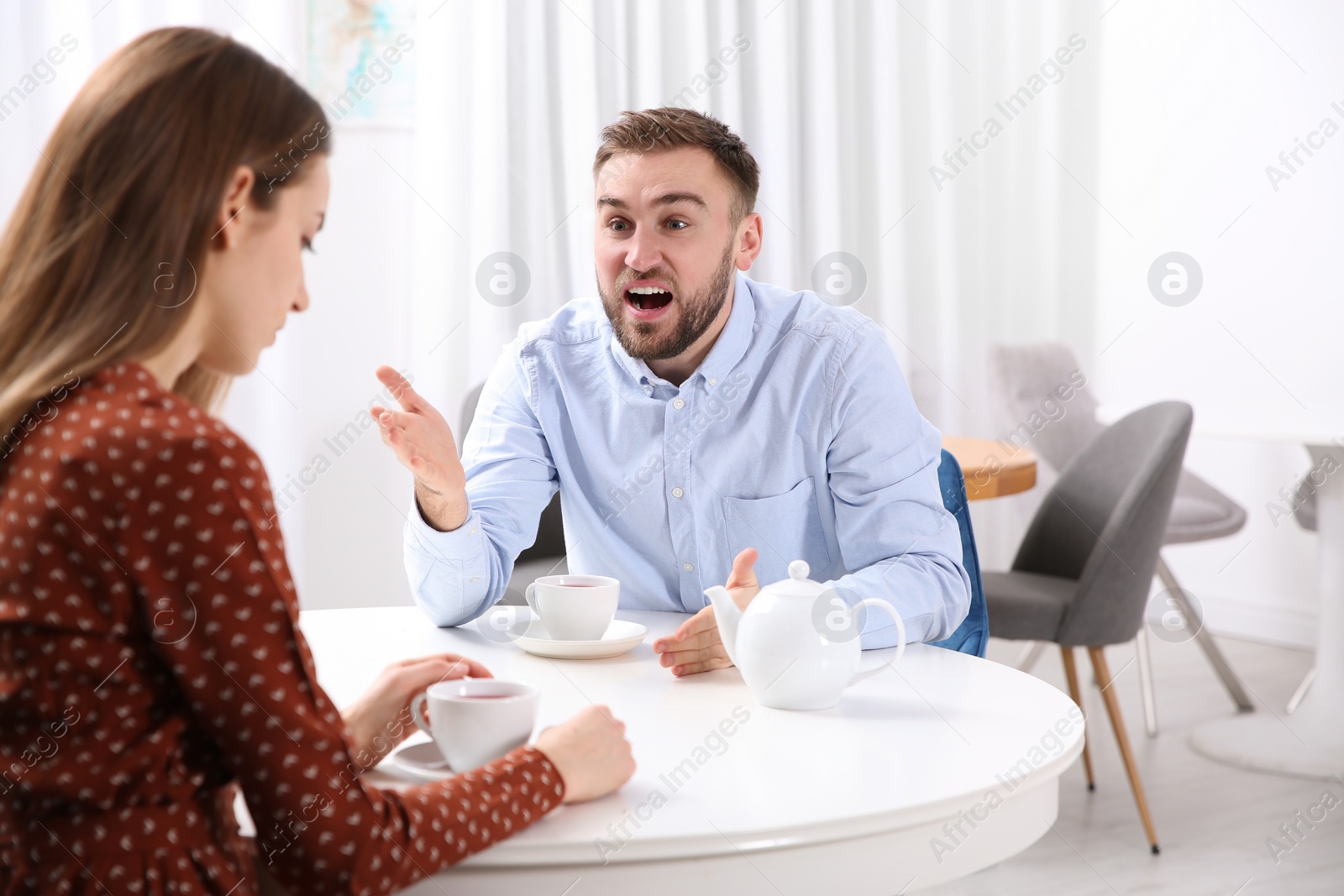 Photo of Couple having quarrel in cafe. Relationship problems