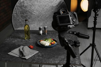 Composition with mozzarella salad on black table in professional photo studio. Food photography