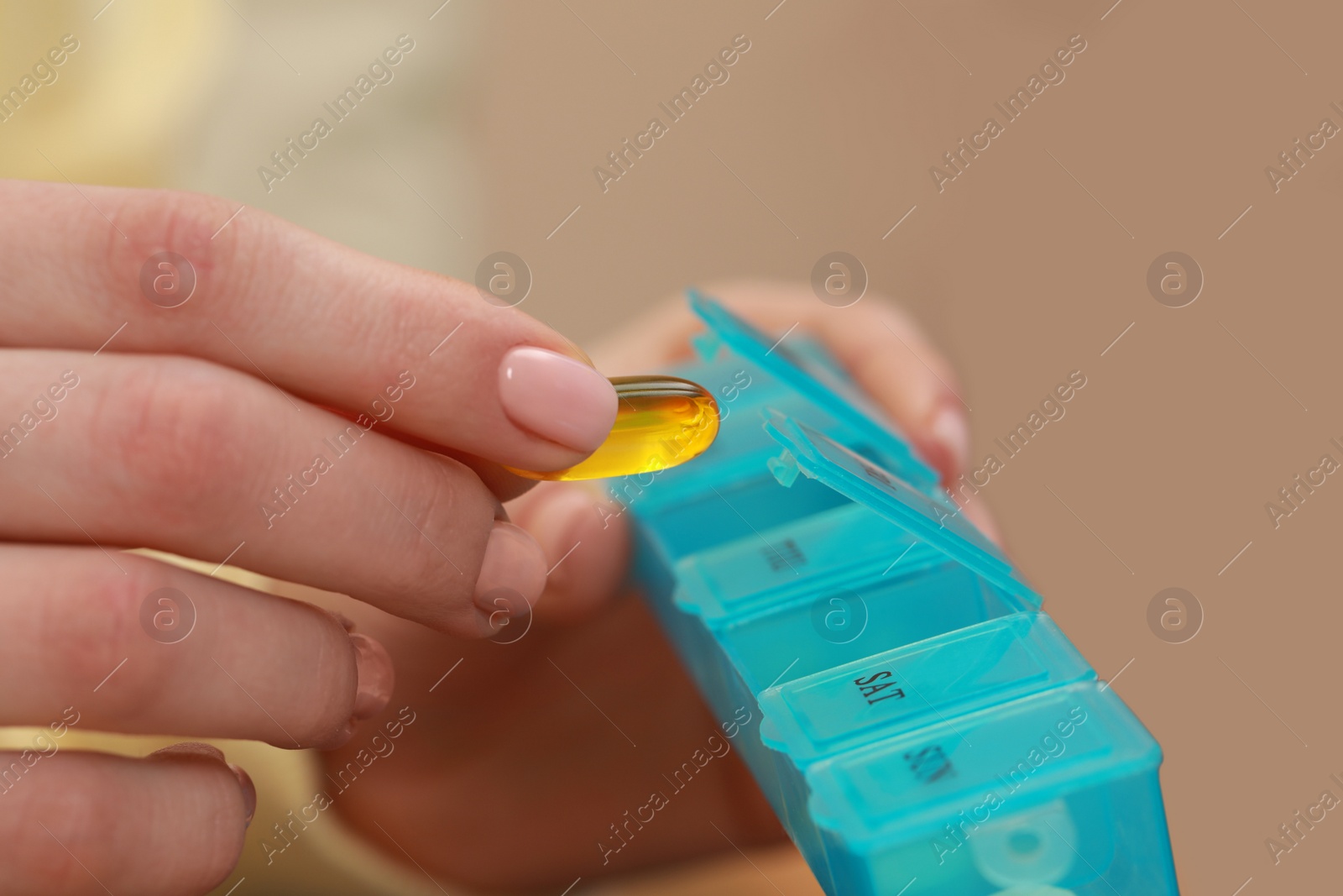 Photo of Woman taking pill from plastic box indoors, closeup