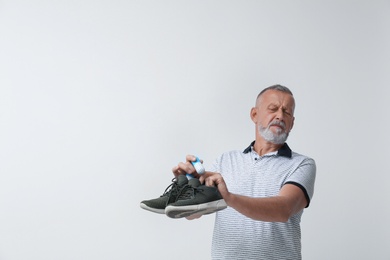 Man putting capsule shoe freshener in footwear on white background. Space for text
