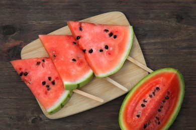 Photo of Cut delicious ripe watermelon on wooden table, flat lay