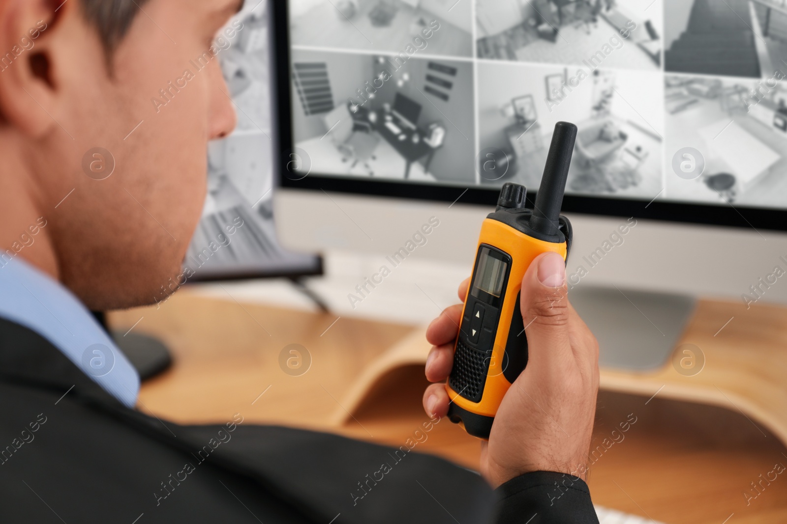 Photo of Male security guard with portable transmitter at workplace, closeup