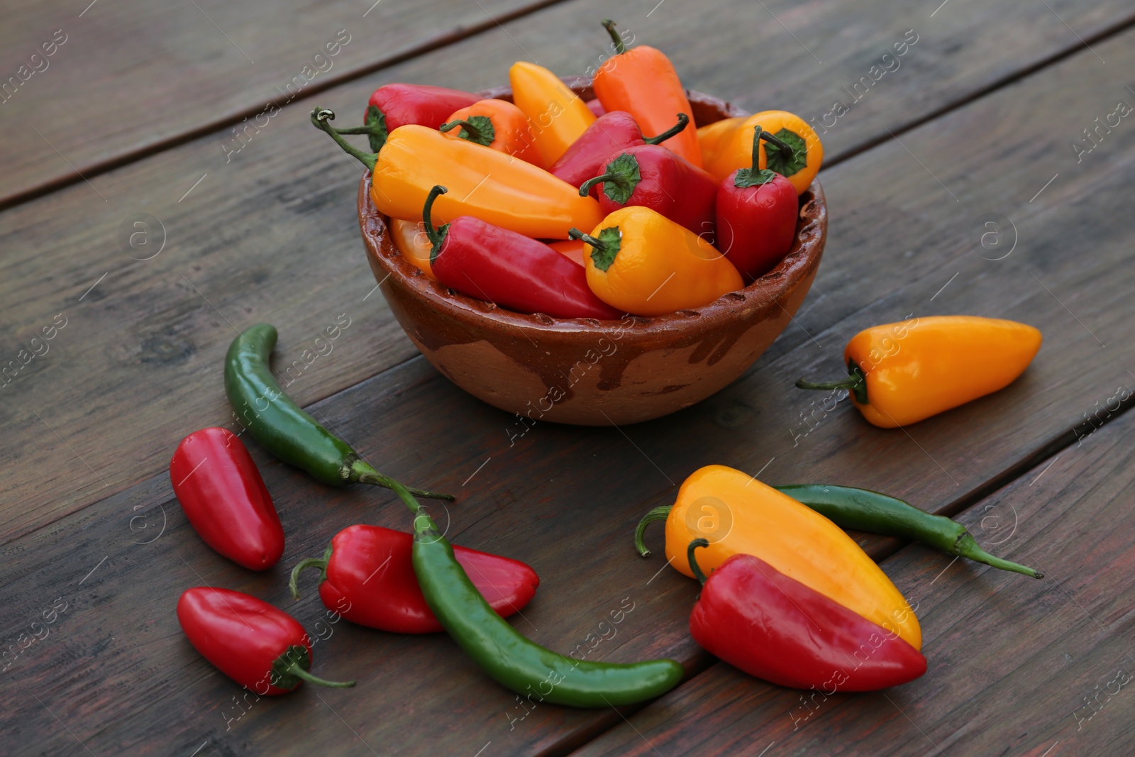 Photo of Different ripe bell peppers on wooden table