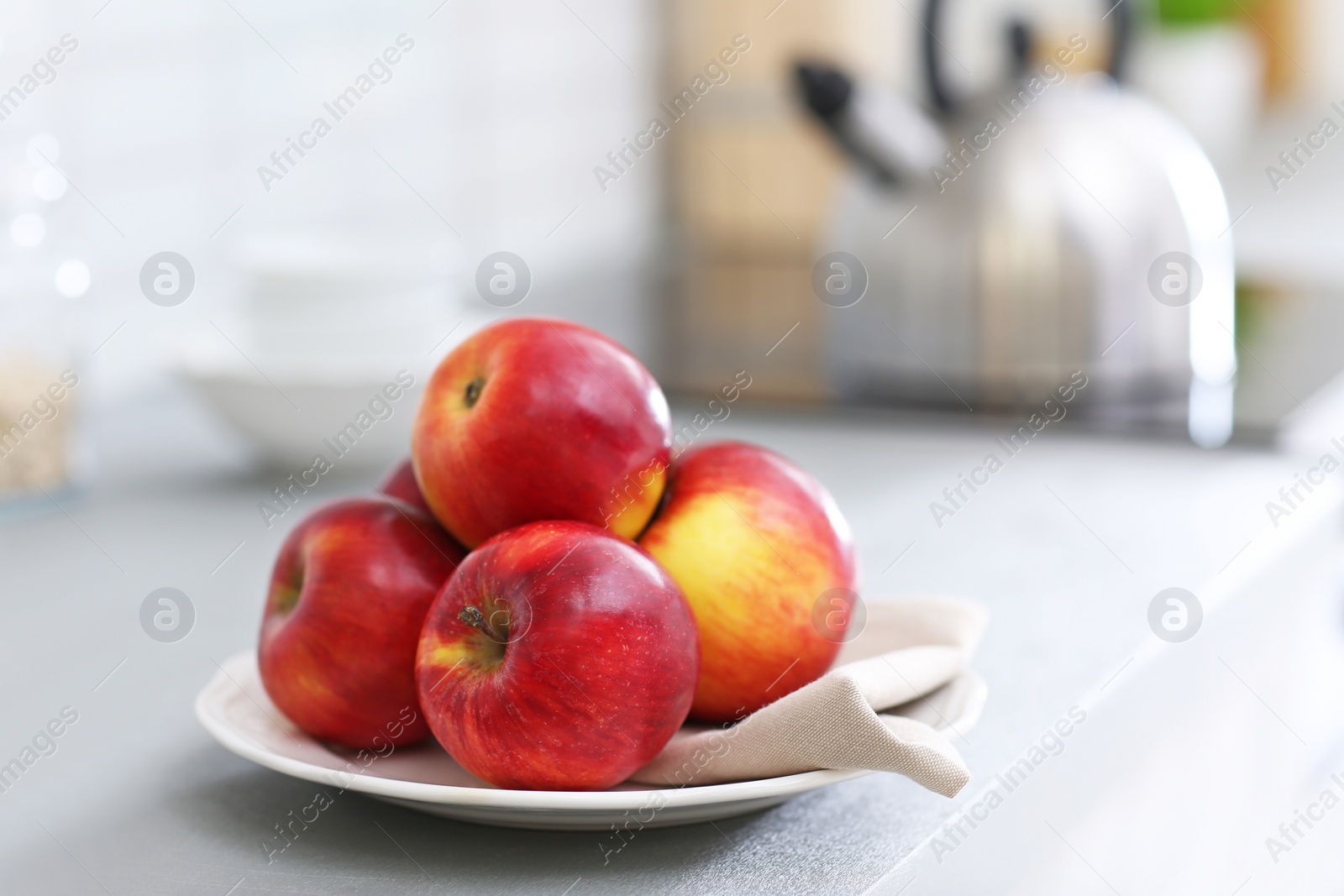 Photo of Plate with ripe red apples on table