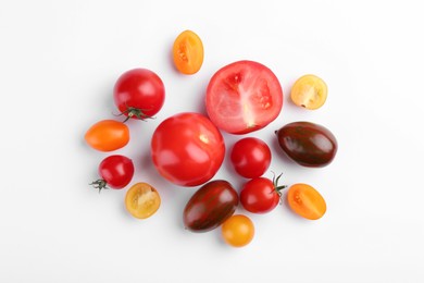 Flat lay composition with different whole and cut tomatoes on white background