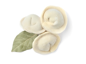 Photo of Frozen raw dumplings with bay leaf on white background, top view