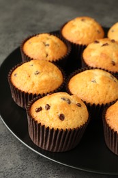 Photo of Delicious freshly baked muffins with chocolate chips on table, closeup