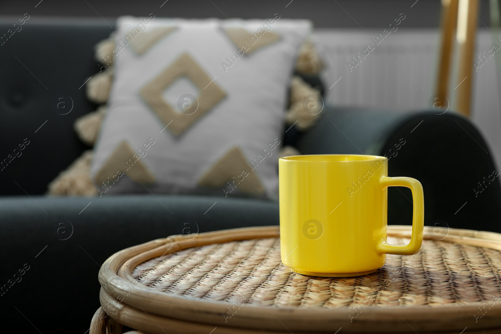 Photo of Ceramic mug on wicker table indoors. Mockup for design