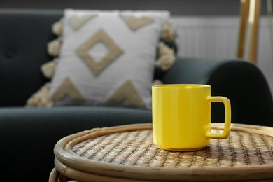 Ceramic mug on wicker table indoors. Mockup for design