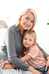 Cute little girl and her grandmother at home