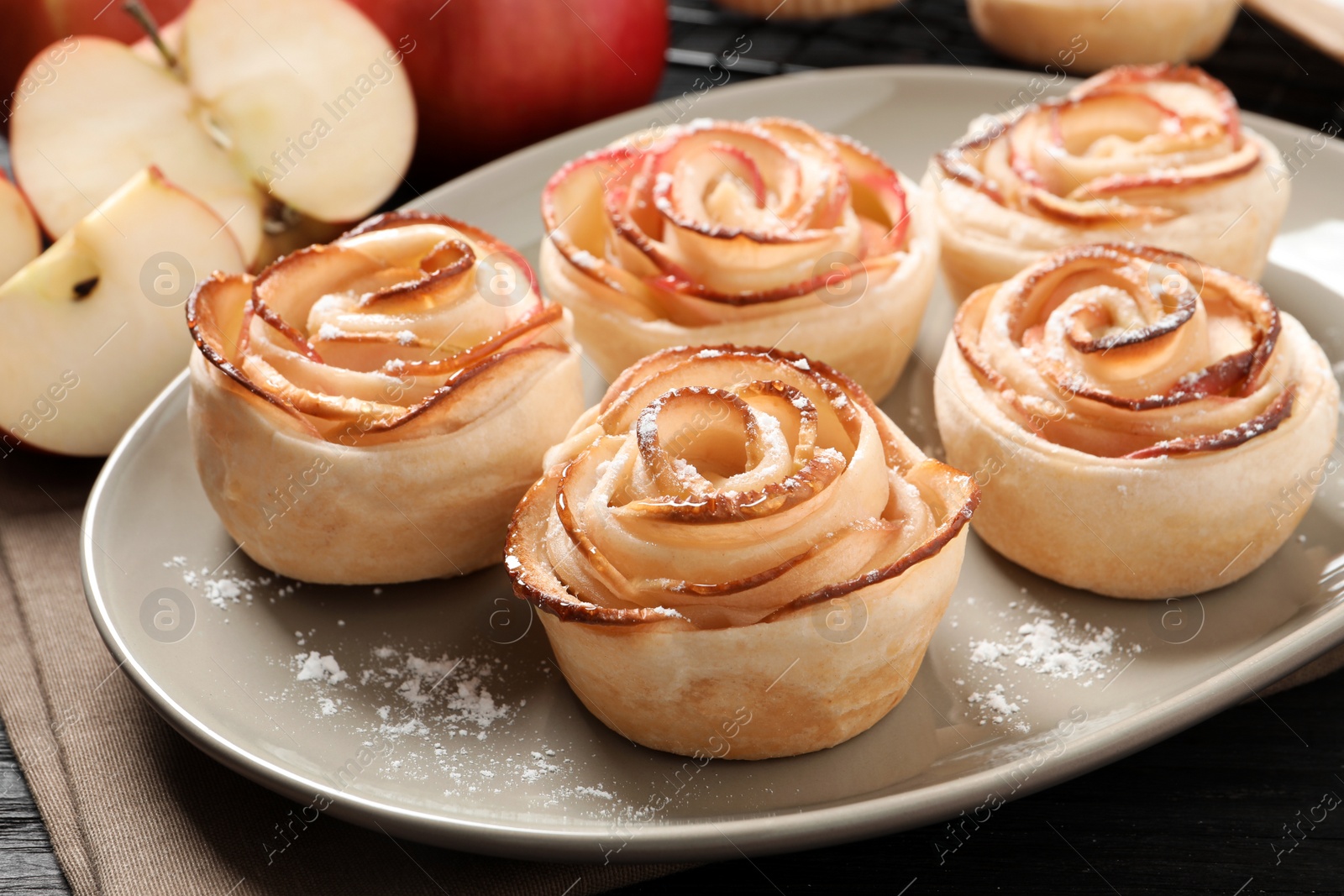 Photo of Freshly baked apple roses on plate, closeup. Beautiful dessert