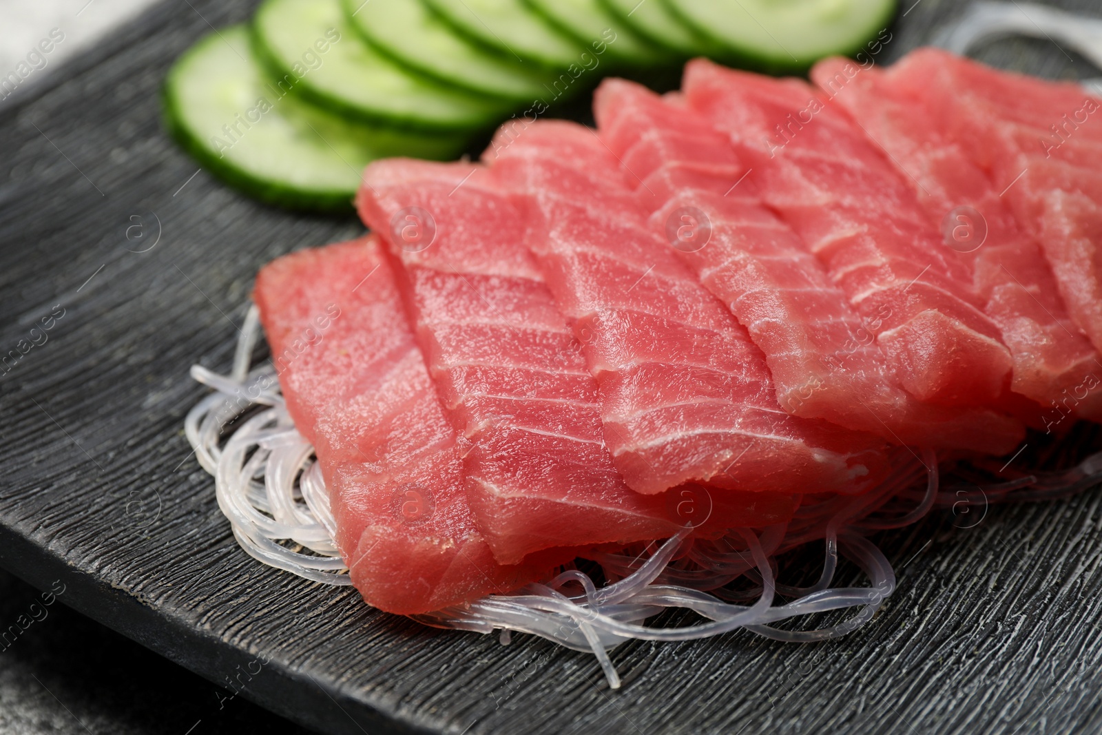 Photo of Tasty sashimi (pieces of fresh raw tuna) and glass noodles on plate, closeup