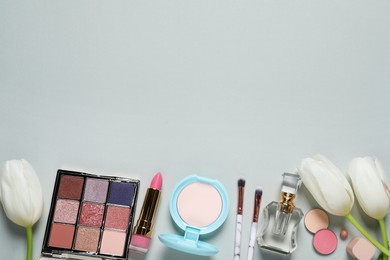 Photo of Flat lay composition with makeup products and beautiful tulips on light grey background. Space for text