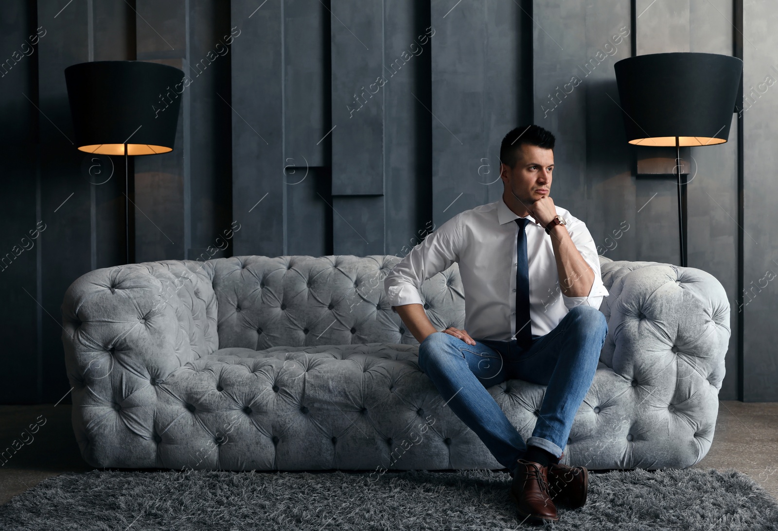 Photo of Handsome businessman on sofa indoors. Luxury lifestyle