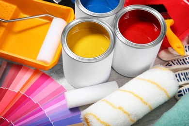 Cans of paint and decorator tools on wooden floor