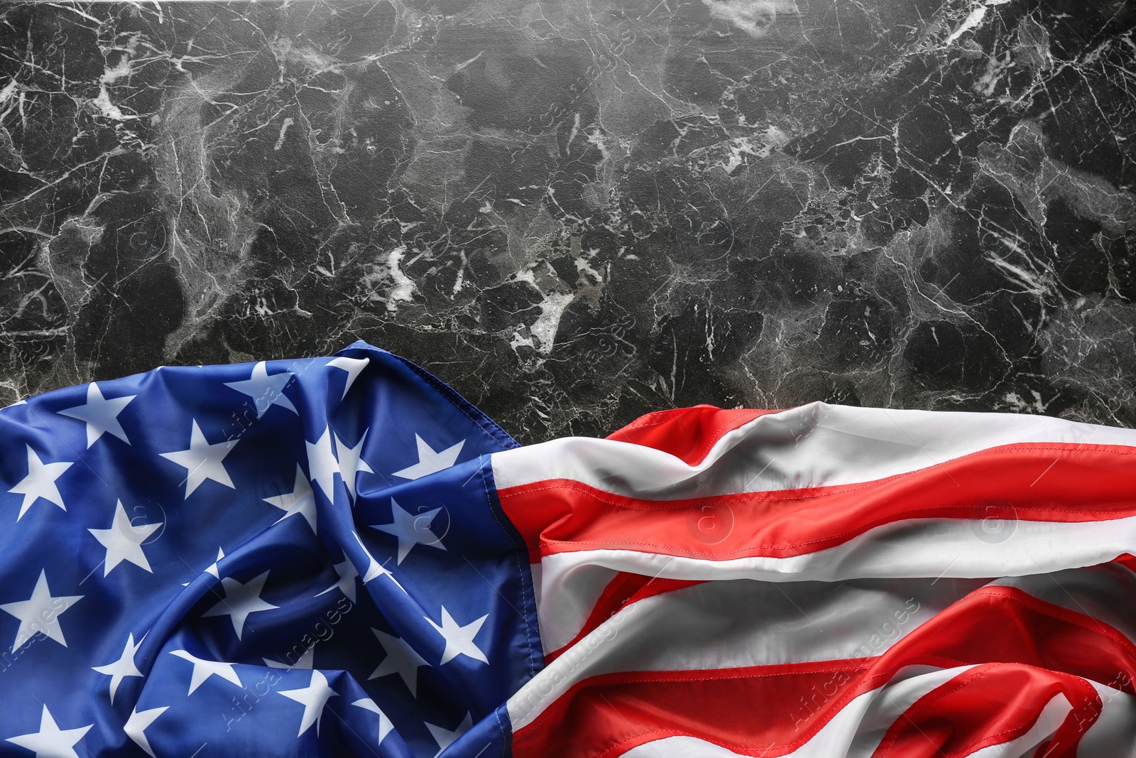 Photo of American flag on marble background, top view. Space for text