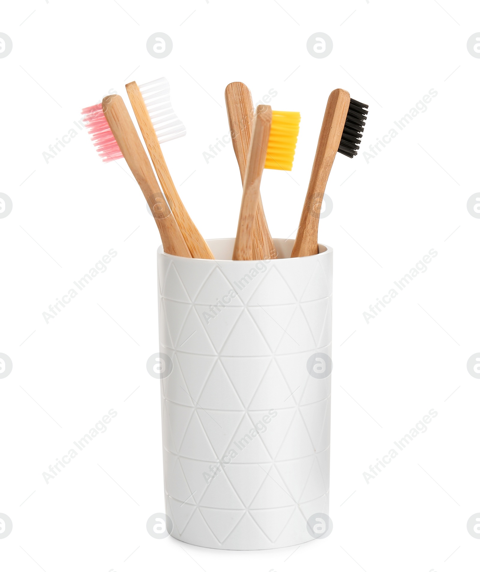 Photo of Bamboo toothbrushes in holder isolated on white