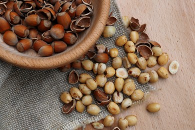 Photo of Tasty organic hazelnuts on wooden table, flat lay