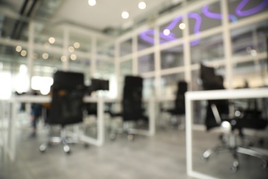 Blurred view of cozy workspaces with tables and chairs in office