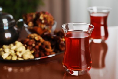 Glasses with tasty Turkish tea and sweets on brown table indoors