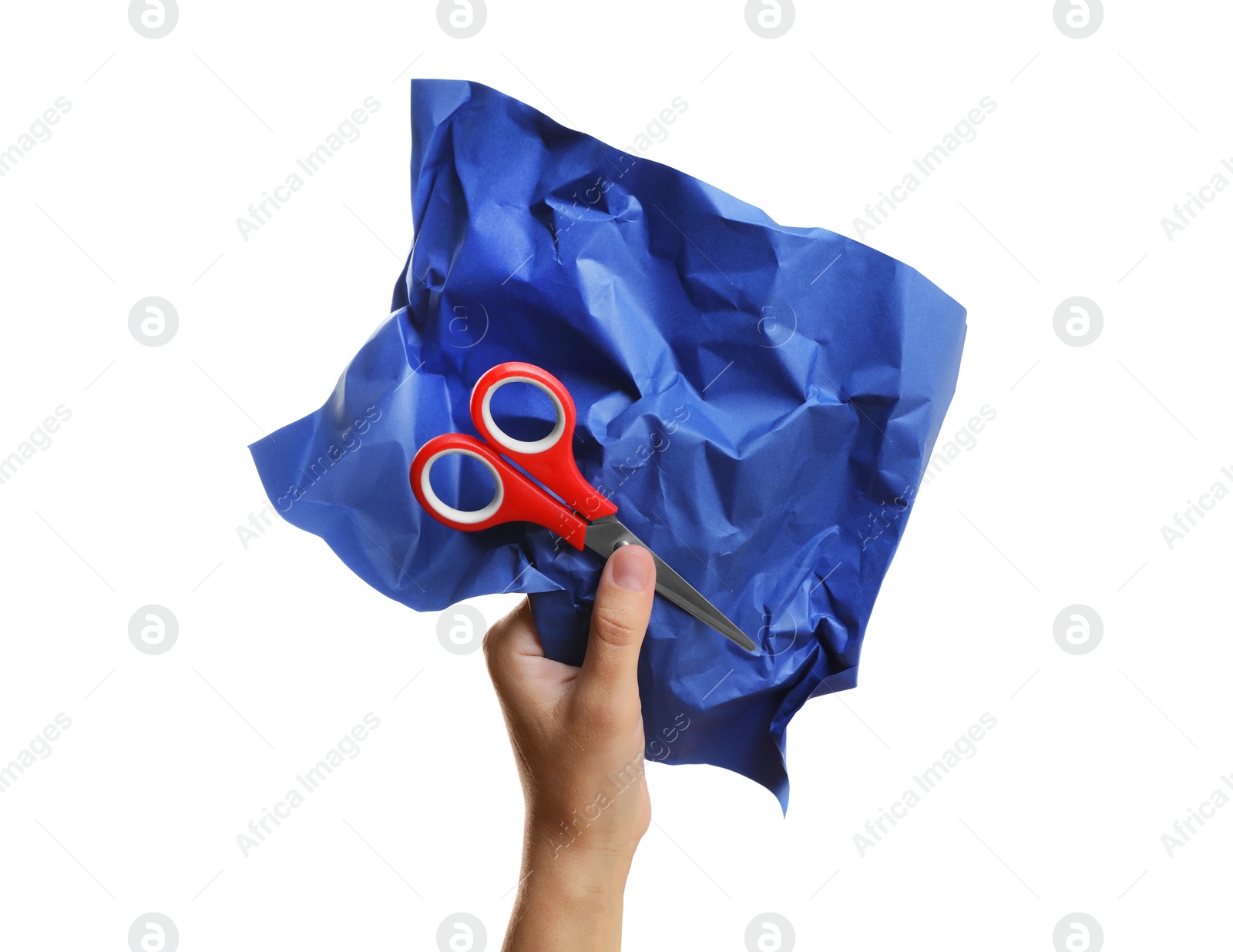 Photo of Woman holding crumpled blue paper and scissors on white background, closeup