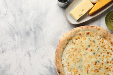 Delicious cheese pizza, oil and different kinds of cheese on light grey textured table, flat lay. Space for text