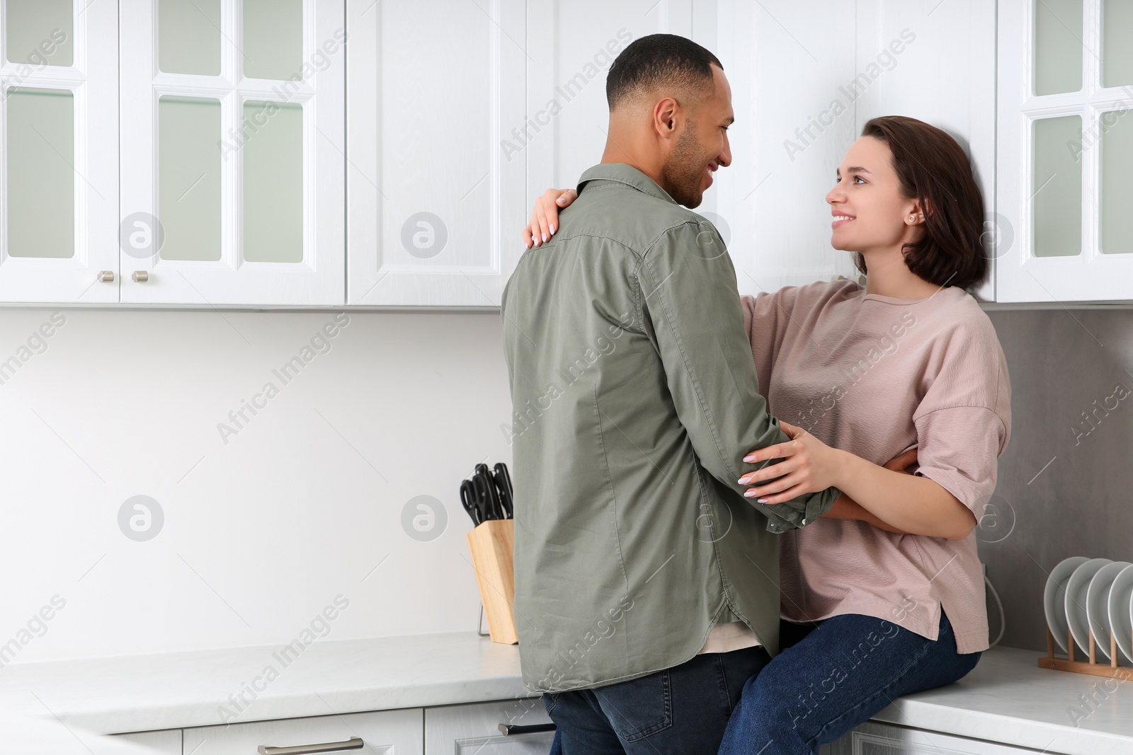 Photo of Dating agency. Happy couple spending time together in kitchen, space for text