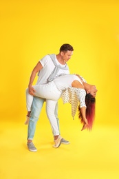 Photo of Beautiful lovely couple dancing on yellow background