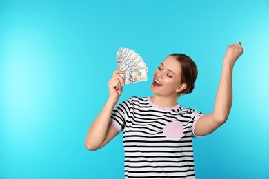 Portrait of emotional young woman with money on color background. Space for text