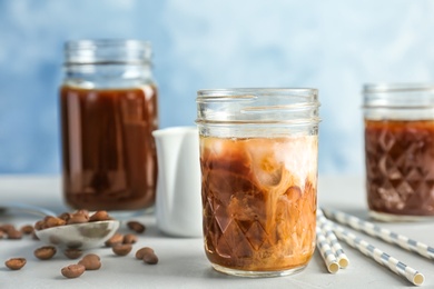 Jar with cold brew coffee and milk on table