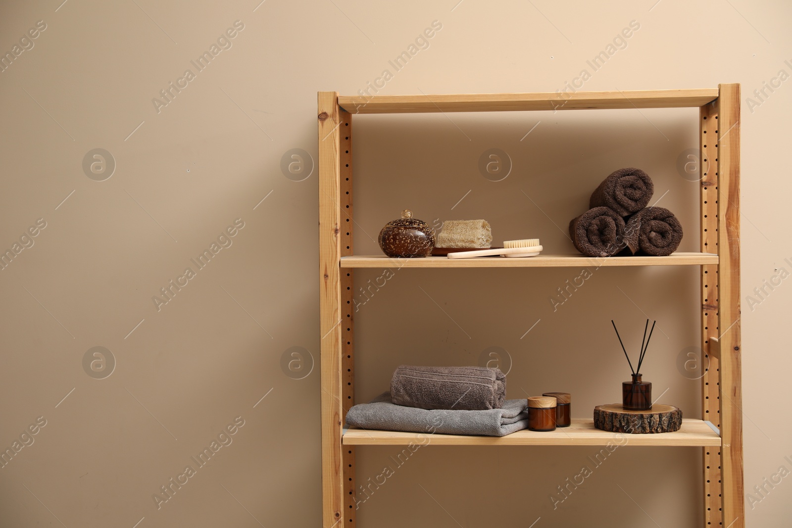 Photo of Soft towels, candles, air freshener and spa products on shelves indoors. Space for text