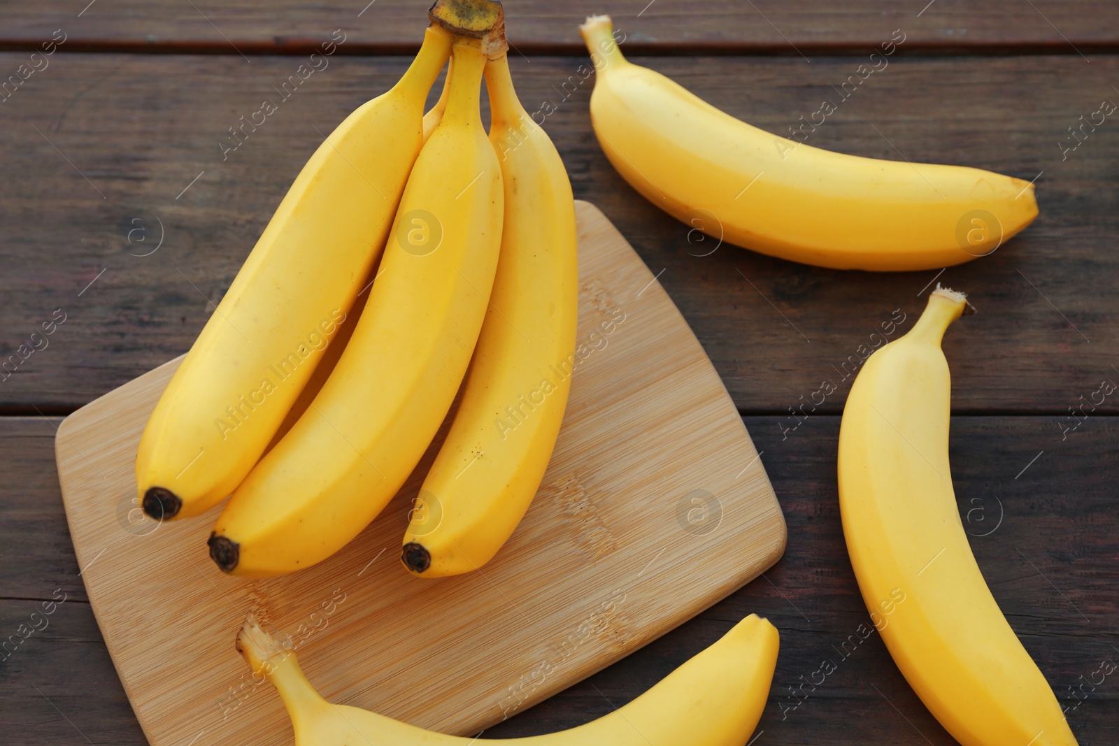 Photo of Delicious yellow bananas on wooden table, closeup