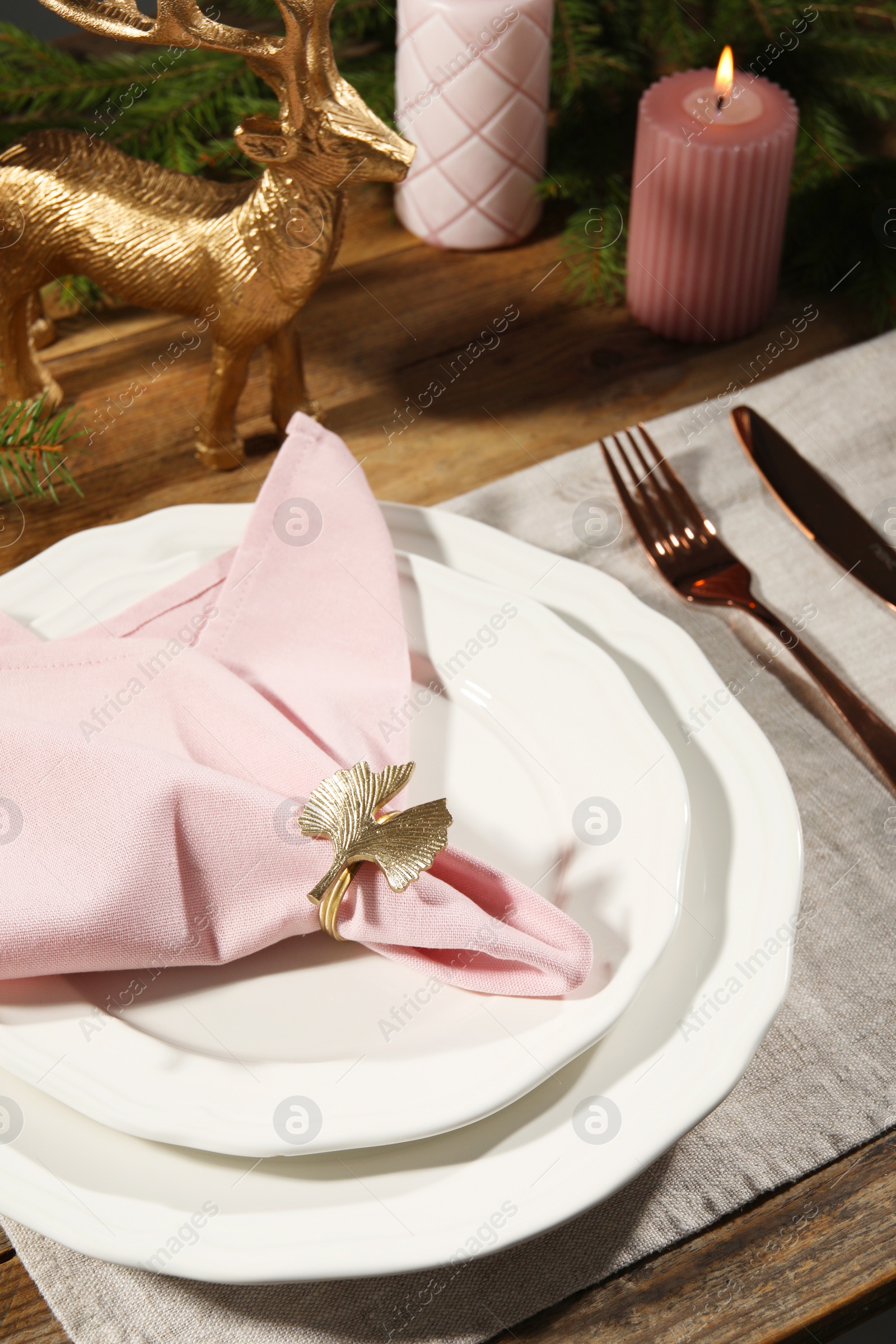 Photo of Stylish table setting with pink fabric napkin, beautiful decorative ring and festive decor, closeup