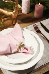 Photo of Stylish table setting with pink fabric napkin, beautiful decorative ring and festive decor, closeup
