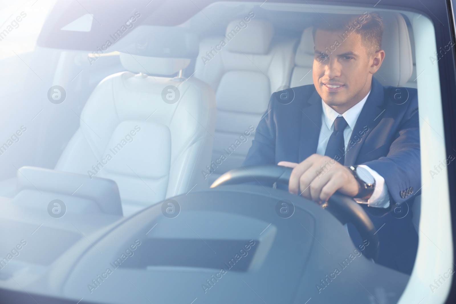 Photo of Handsome man driving his modern car, view from outside