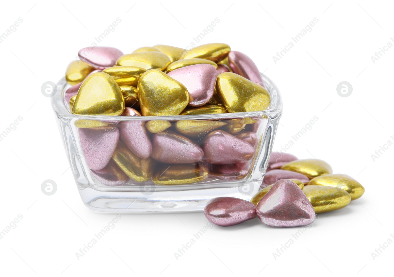 Photo of Glass bowl and many delicious heart shaped candies on white background