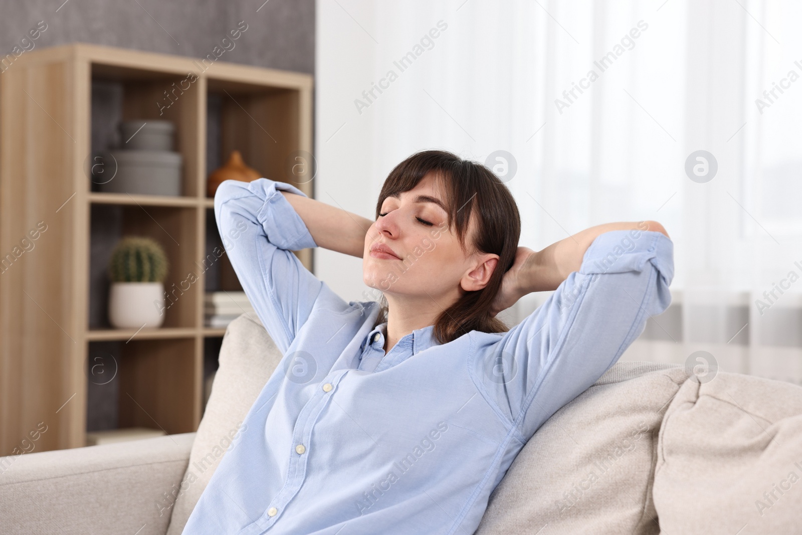 Photo of Beautiful young housewife on sofa at home