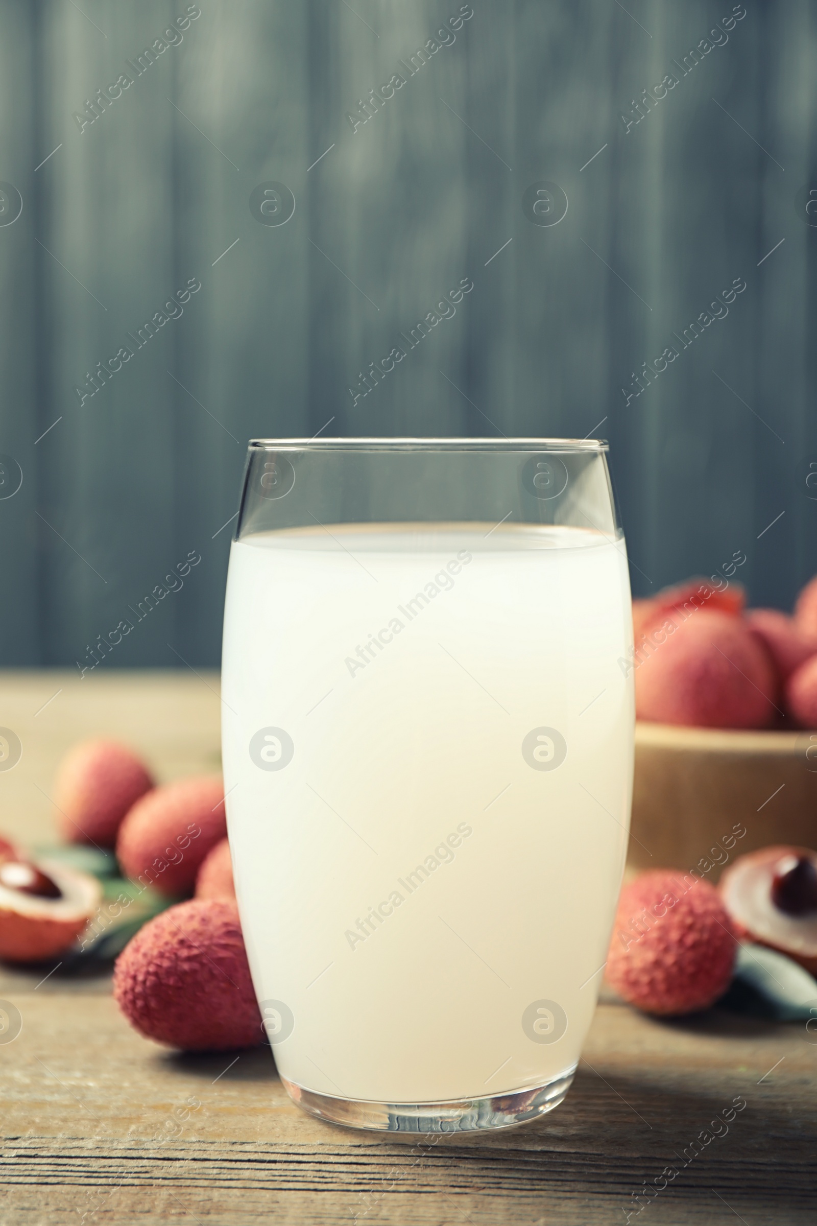 Photo of Fresh lychee juice on wooden table, closeup