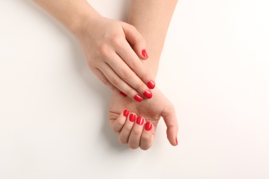 Woman with red manicure on white background, top view. Nail polish trends