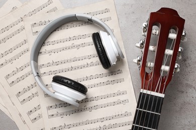 Composition with guitar and music notations on grey table, flat lay