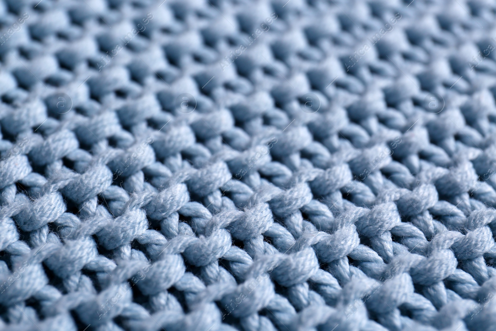 Photo of Beautiful light blue knitted fabric as background, closeup