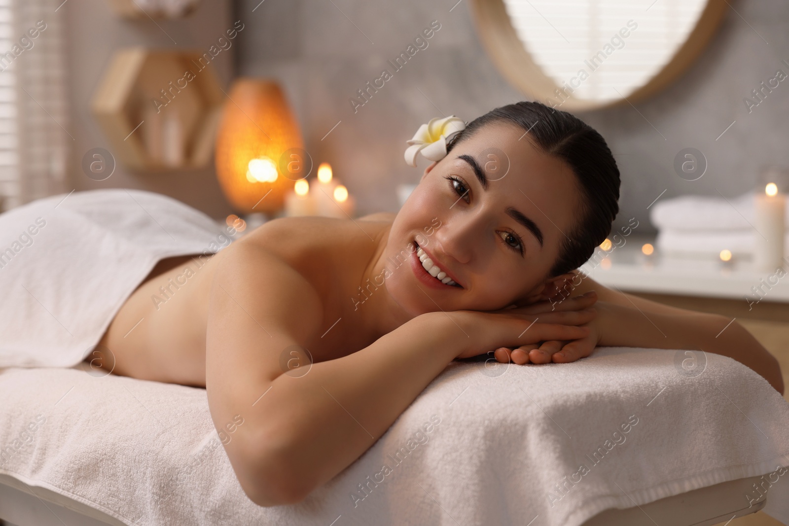 Photo of Beautiful woman relaxing on massage couch in spa salon