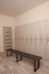 Blurred view of changing room with bench and lockers