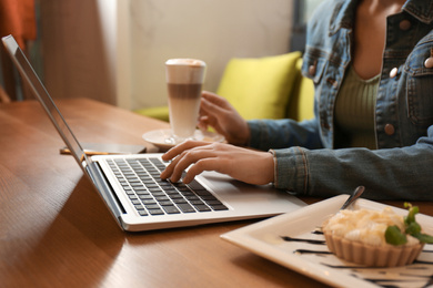 Photo of Blogger working with laptop in cafe, closeup