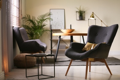 Photo of Stylish living room interior with comfortable armchair and window blinds